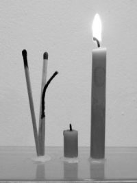 Brennende Kerze neben abgebrannter Kerze daneben Streichholz neu, Streichholz , das kurz brannte und abgebranntes Streichholz